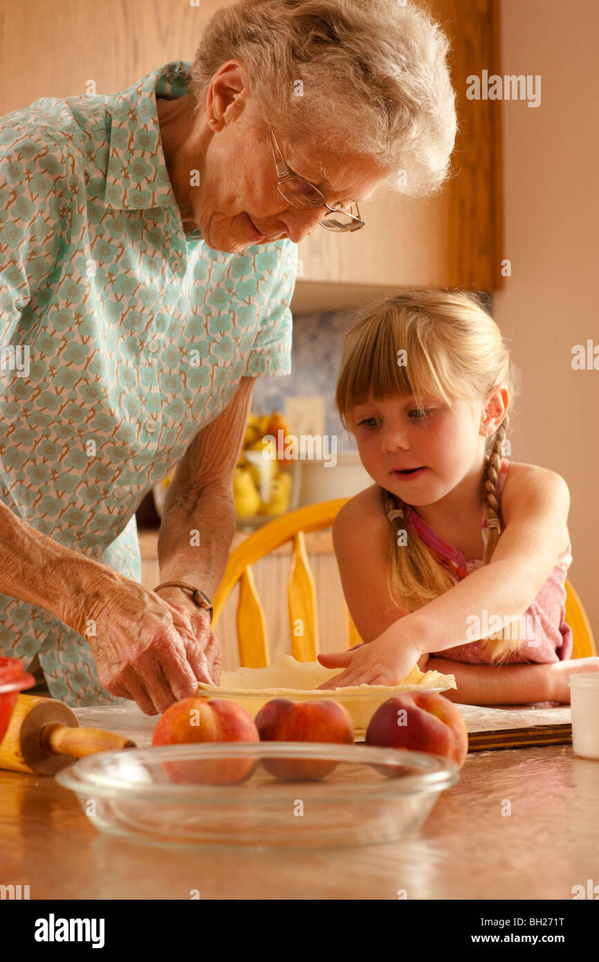 Petite fille de cinq ans aider grand-mère Préparer la pâte ; Redvers, Saskatchewan, Canada Banque D'Images