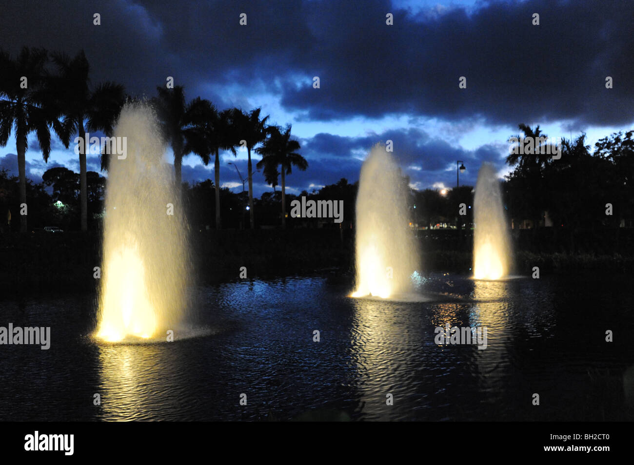 3 Les fontaines d'eau dans la nuit dans le lac à Waterside boutique de Naples Florida USA Banque D'Images