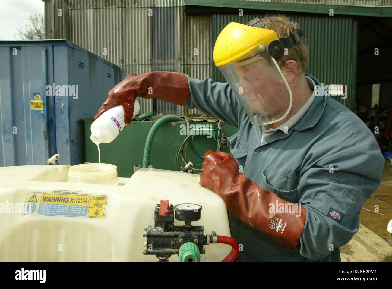 Verser dans les pesticides agriculteurs son pulvérisateur Banque D'Images