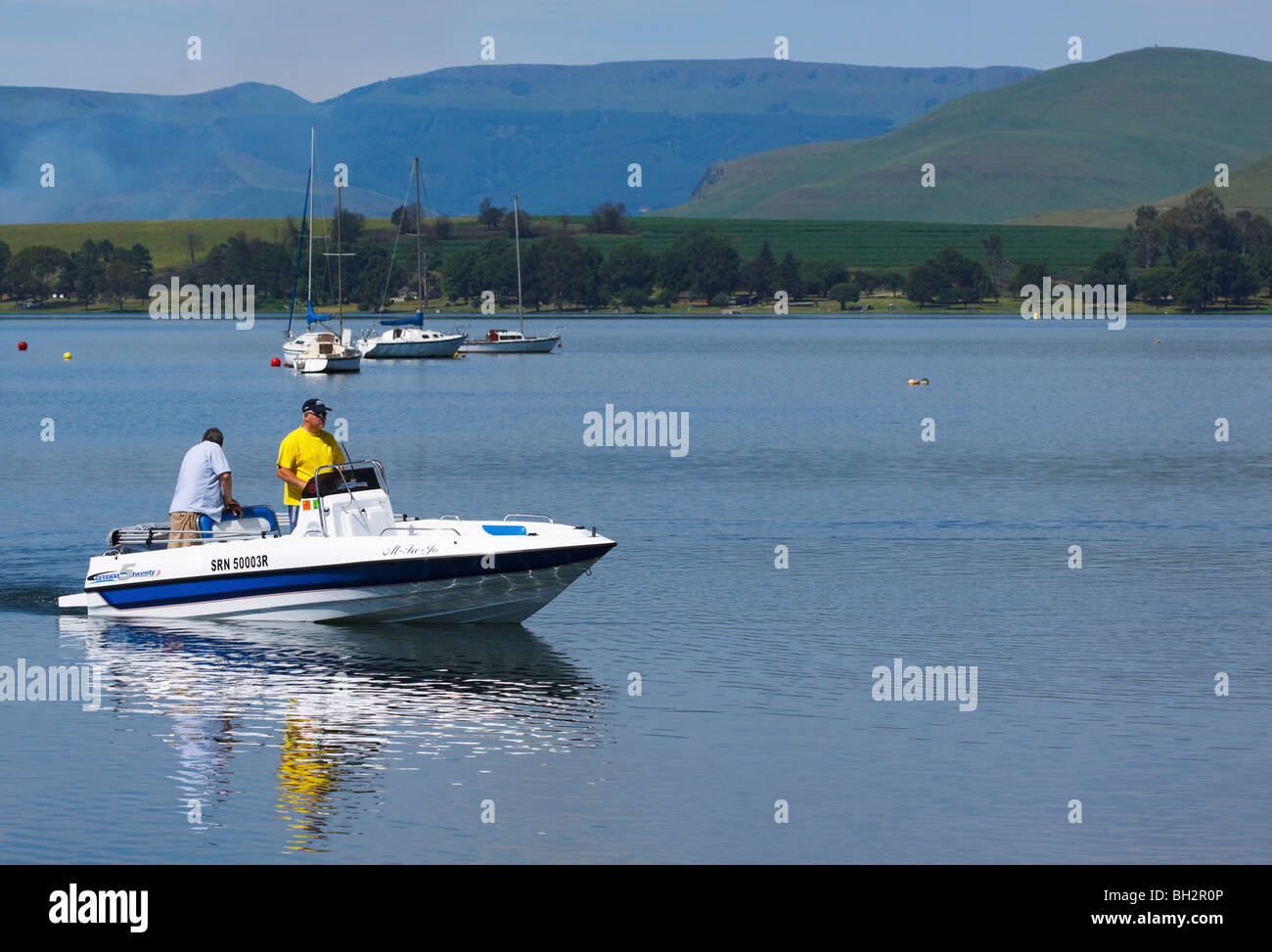 Deux hommes en bateau à moteur sur Midmar dam, Midlands, Kwazulu Natal, Afrique du Sud. Banque D'Images
