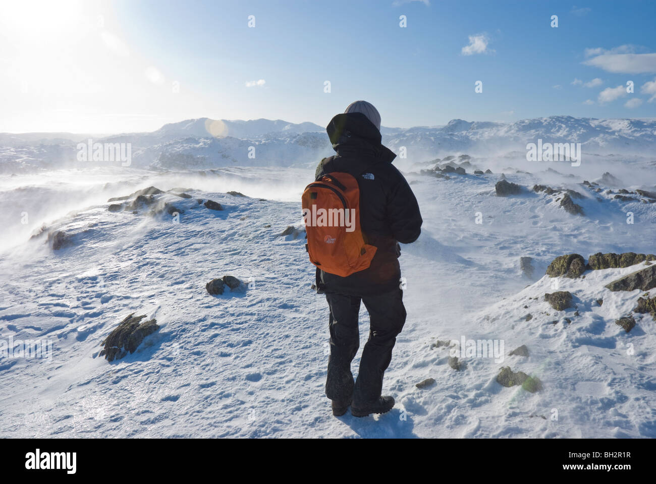 Seule femme walker avec sac à dos et des vêtements d'hiver au sommet d'acier couvertes de neige est tombée dans le Lake District de Cumbrie. Banque D'Images