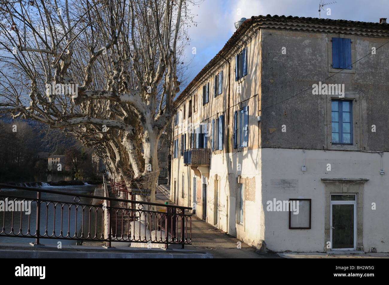 Maisons et de platanes le long de la rivière Vidourle, Quissac, Gard, sud de la France Banque D'Images