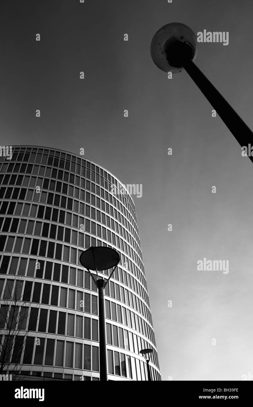 Abstraite de moderne une tour d'appartements ou de bureaux contre un skyline avec lampe posts en premier plan Banque D'Images