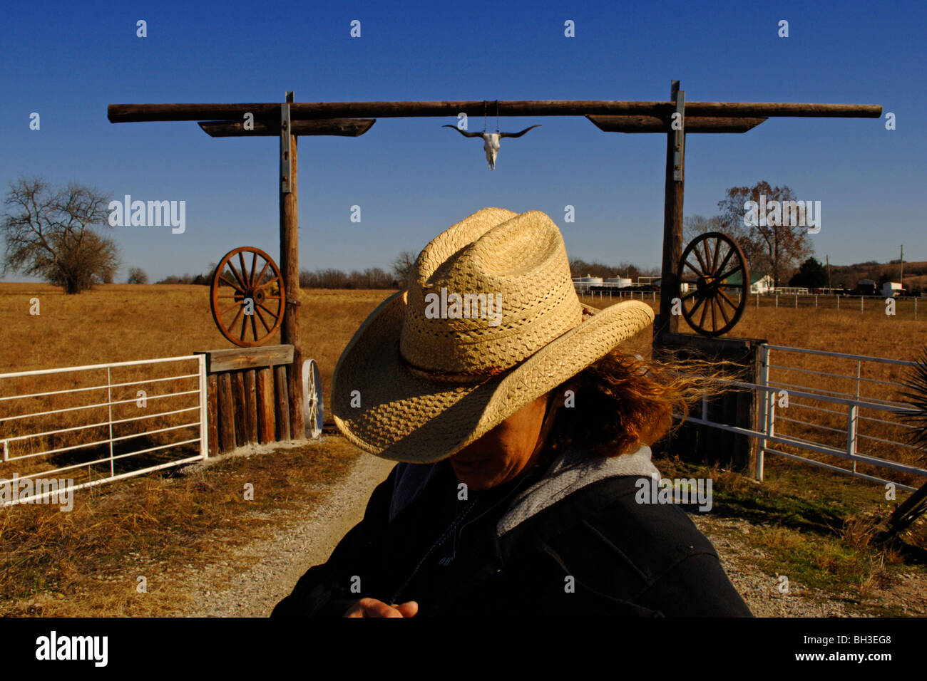 Une minorité d'enquêtes femme la campagne alors qu'il se tenait devant une passerelle en bois rustique comme elle travaille comme un éleveur de bétail Banque D'Images