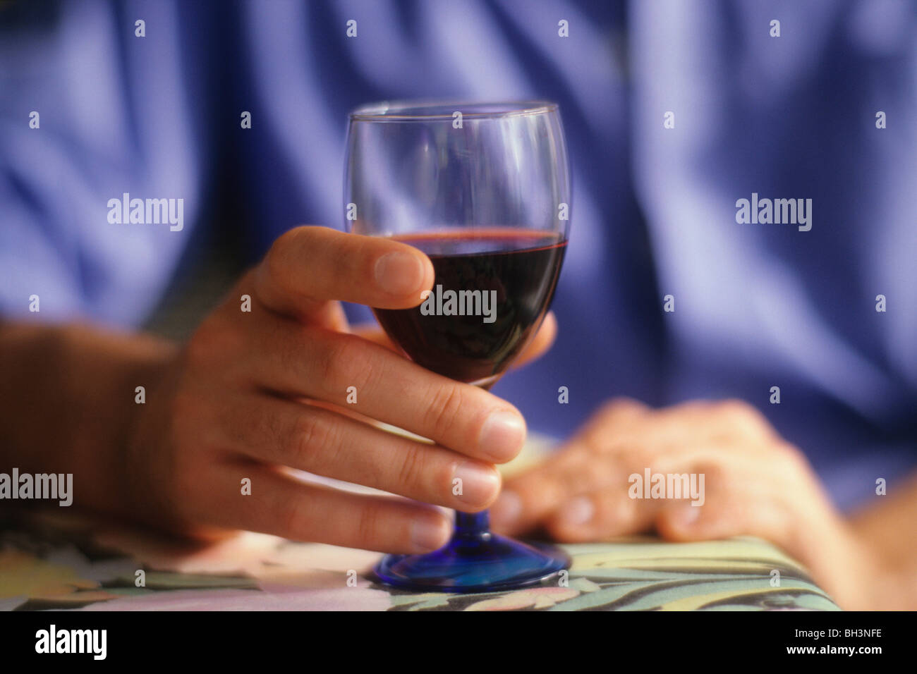 Homme tenant un verre de vin rouge Banque D'Images