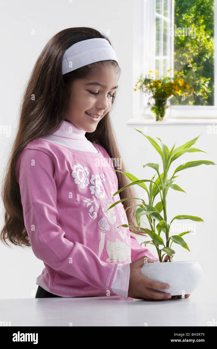 Girl holding a potted plant Banque D'Images