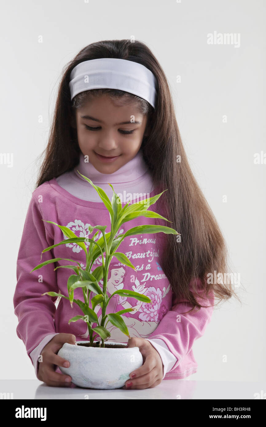 Girl holding a potted plant Banque D'Images