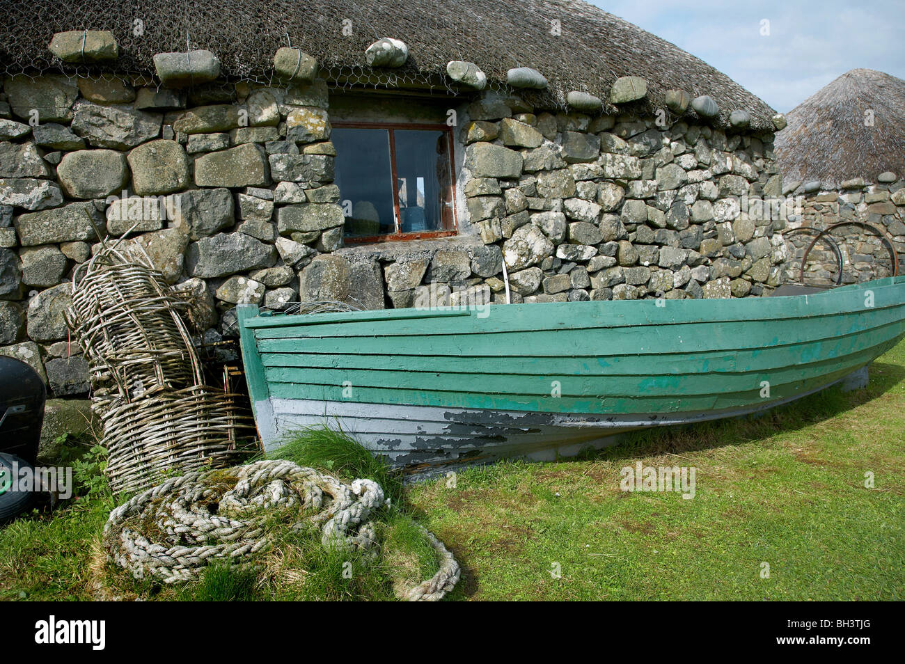 Crofts chaume et bateau de pêche au Kilmuir. Banque D'Images