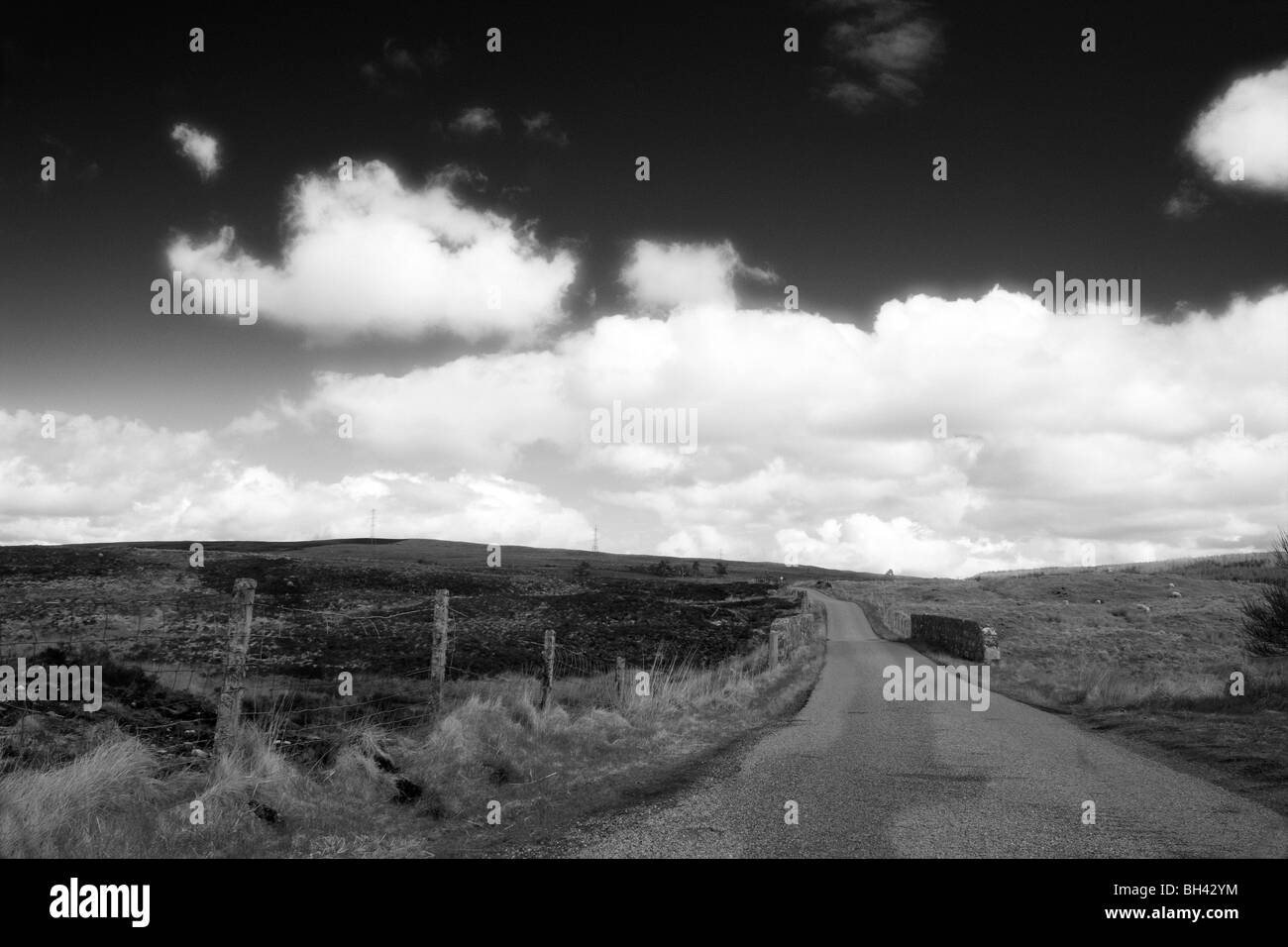 Route à travers la lande dans les Highlands écossais avec ciel dramatique. Banque D'Images