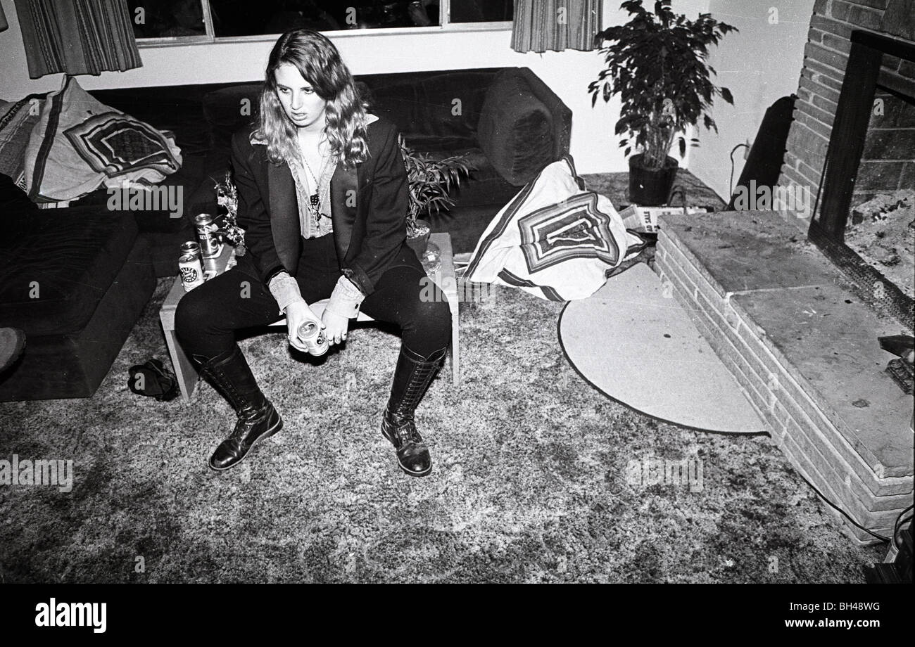 Une femme d'âge de l'adolescence se bloque dans un salon au cours d'une house party. goth punk des années 80, 1989 Femme blonde bottes mode collants noirs Banque D'Images