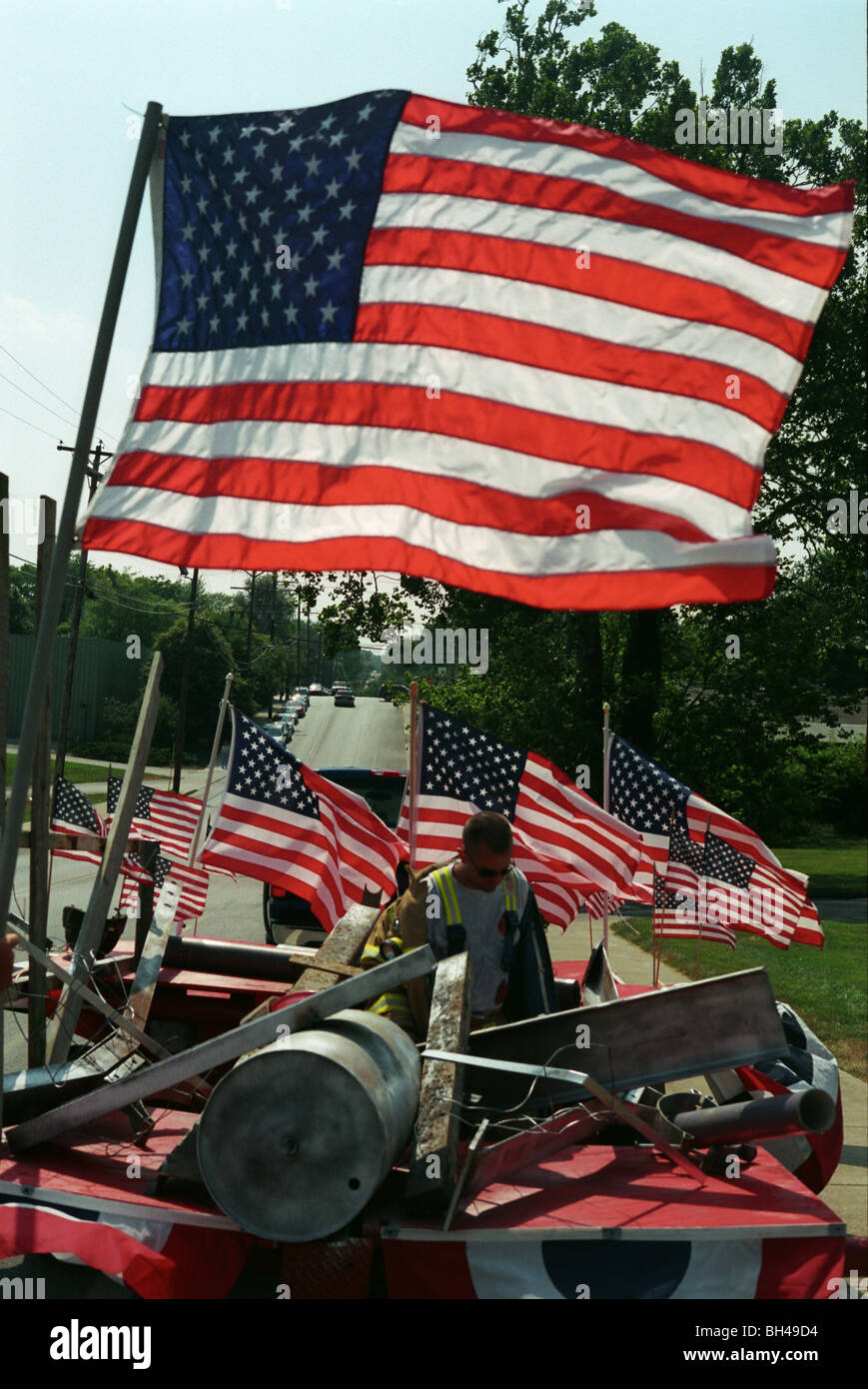 Un pompier se dresse sur un flotteur, avec des drapeaux américains et un hommage aux pompiers décédés le 11 septembre 2001. patriotic Banque D'Images