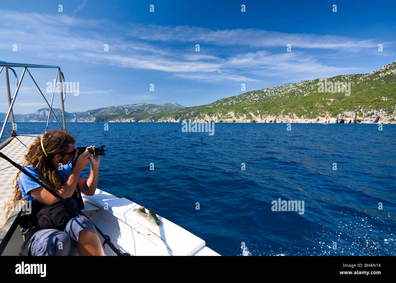 Photographe sur un bateau dans la plage de Cala Luna, Sardaigne, île de l'Italie. Eau bleu clair dans la baie de Cala Luna, Mer Méditerranée. Banque D'Images