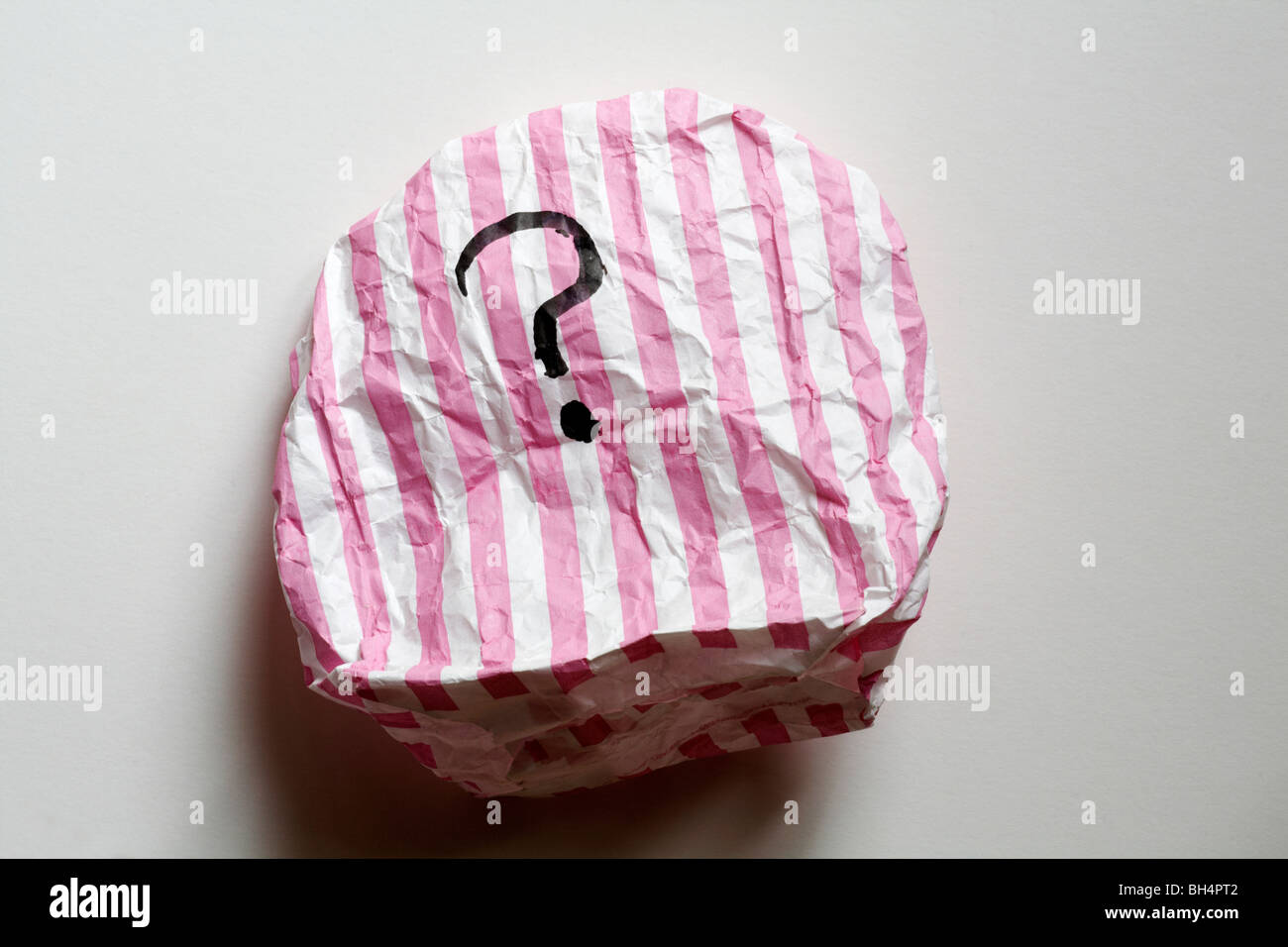 sac en papier à rayures roses et blanches avec point d'interrogation - concept d'intrigue mystère surprise Banque D'Images