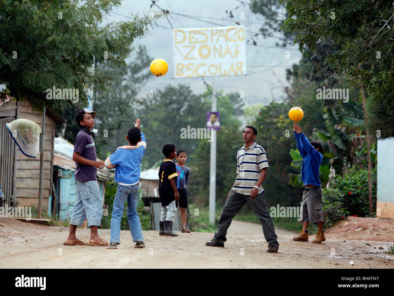 Un enseignant de l'école dans un petit village joue balle avec sa étudiants dans le cadre d'un signe fait main zone scolaire, la République Dominicaine Banque D'Images
