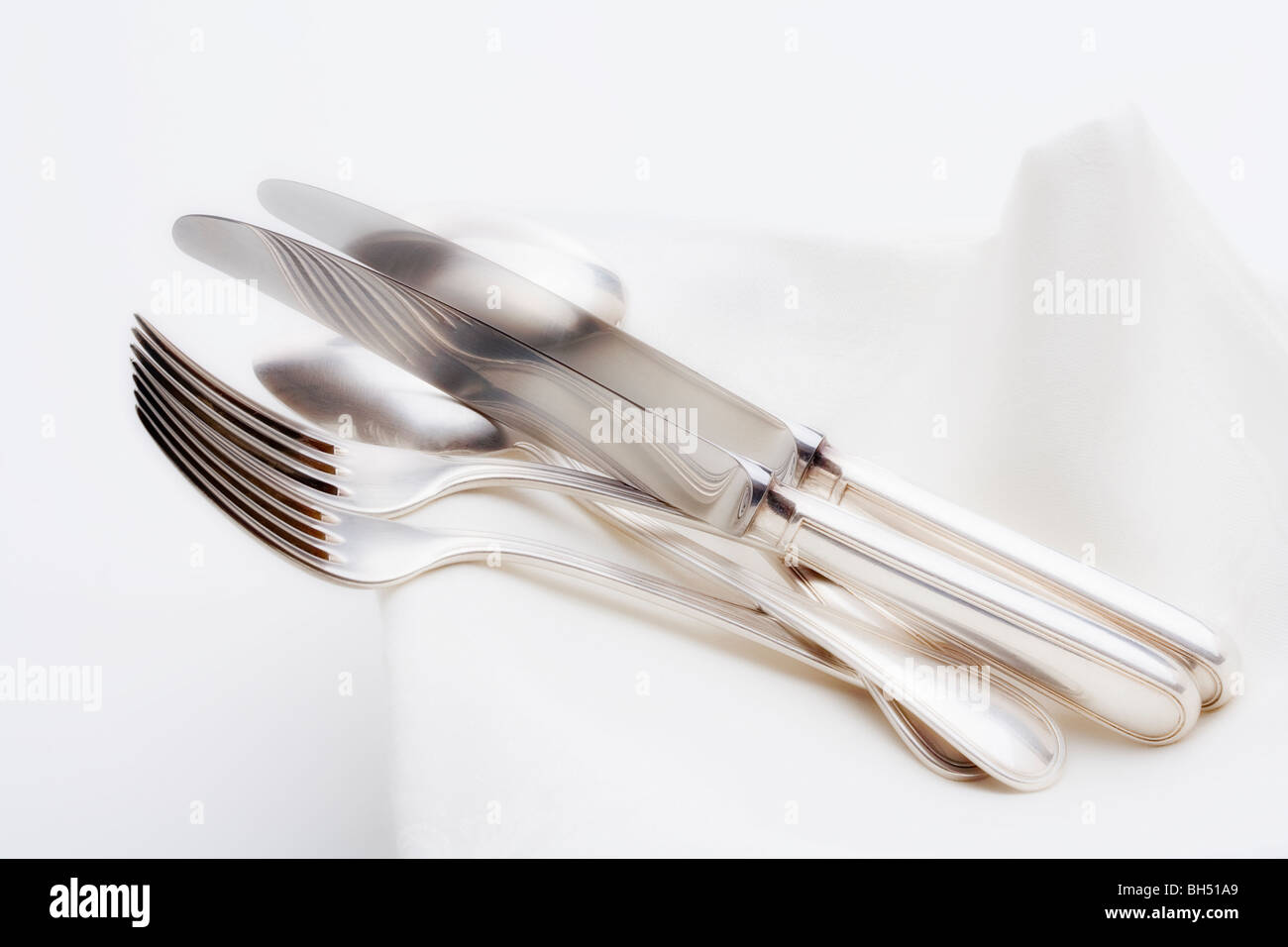 De l'argenterie - gros plan du couteau fourchette et cuillère élégante sur un tissu blanc Banque D'Images