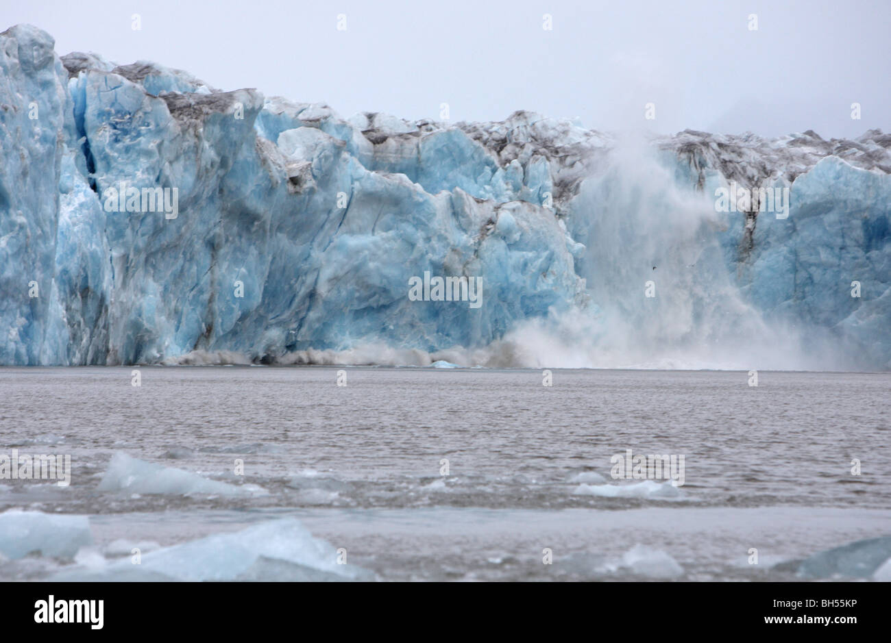 Glacier de glace bleue la mise bas dans l'océan créant un énorme splash et vague suivante Banque D'Images