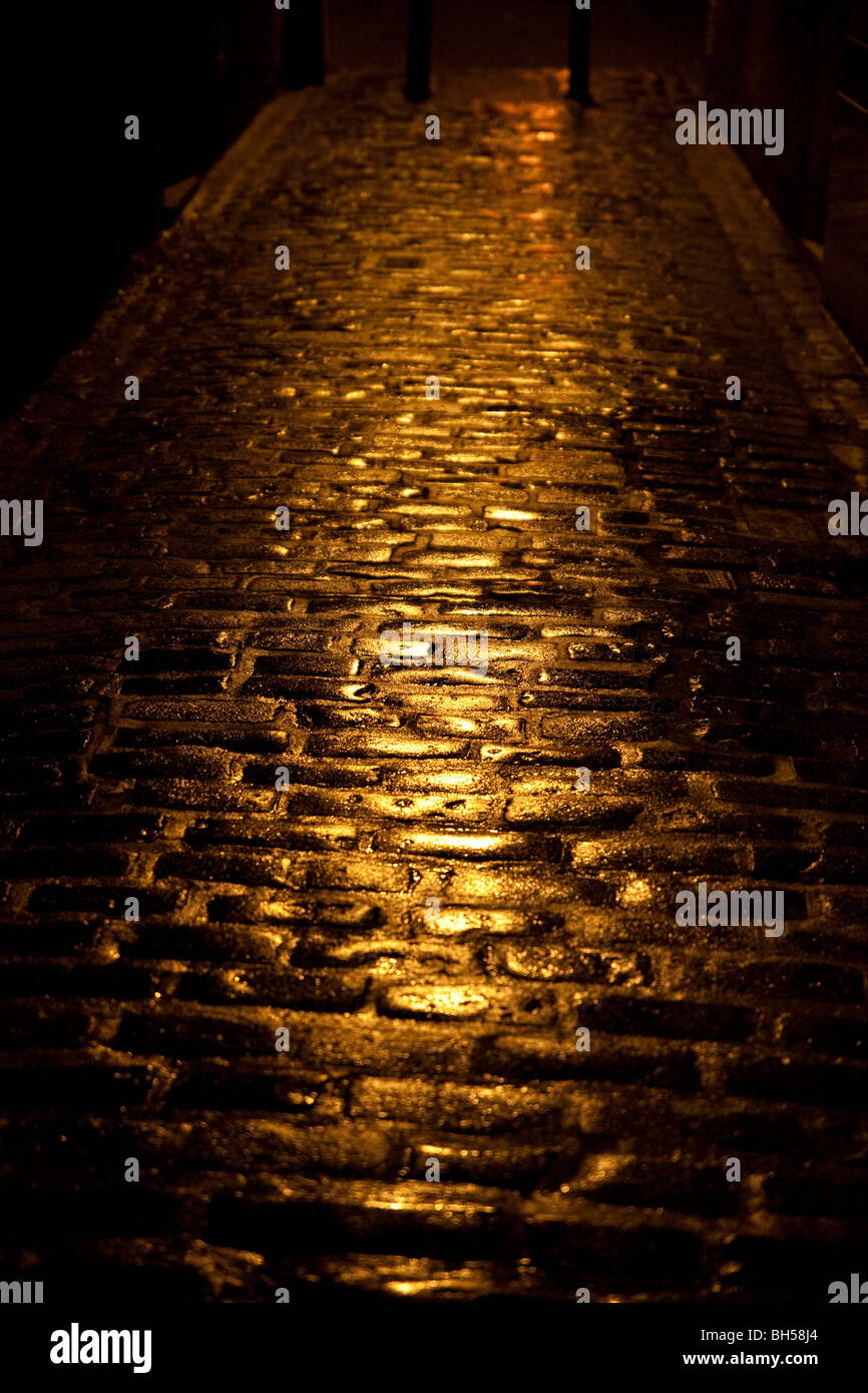 Pavés mouillés dans la nuit dans une ruelle ou wynd à Kelso, Ecosse Banque D'Images