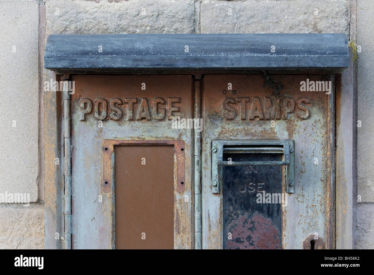 Timbre ancien désaffecté distributeur automatique vu sur le mur d'un bureau de poste écossais Banque D'Images