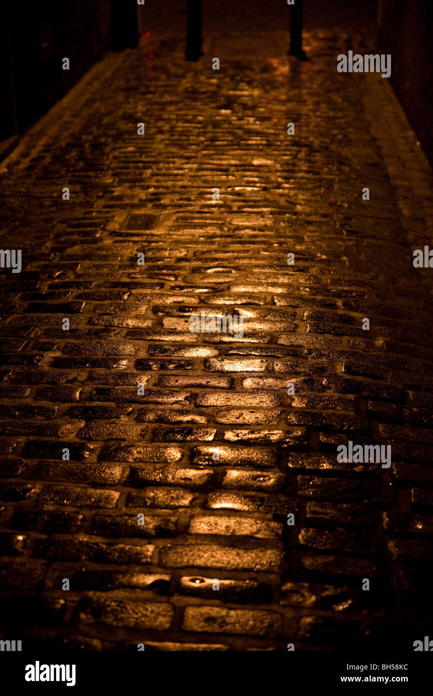 Pavés mouillés dans la nuit dans une ruelle ou wynd à Kelso, Ecosse Banque D'Images