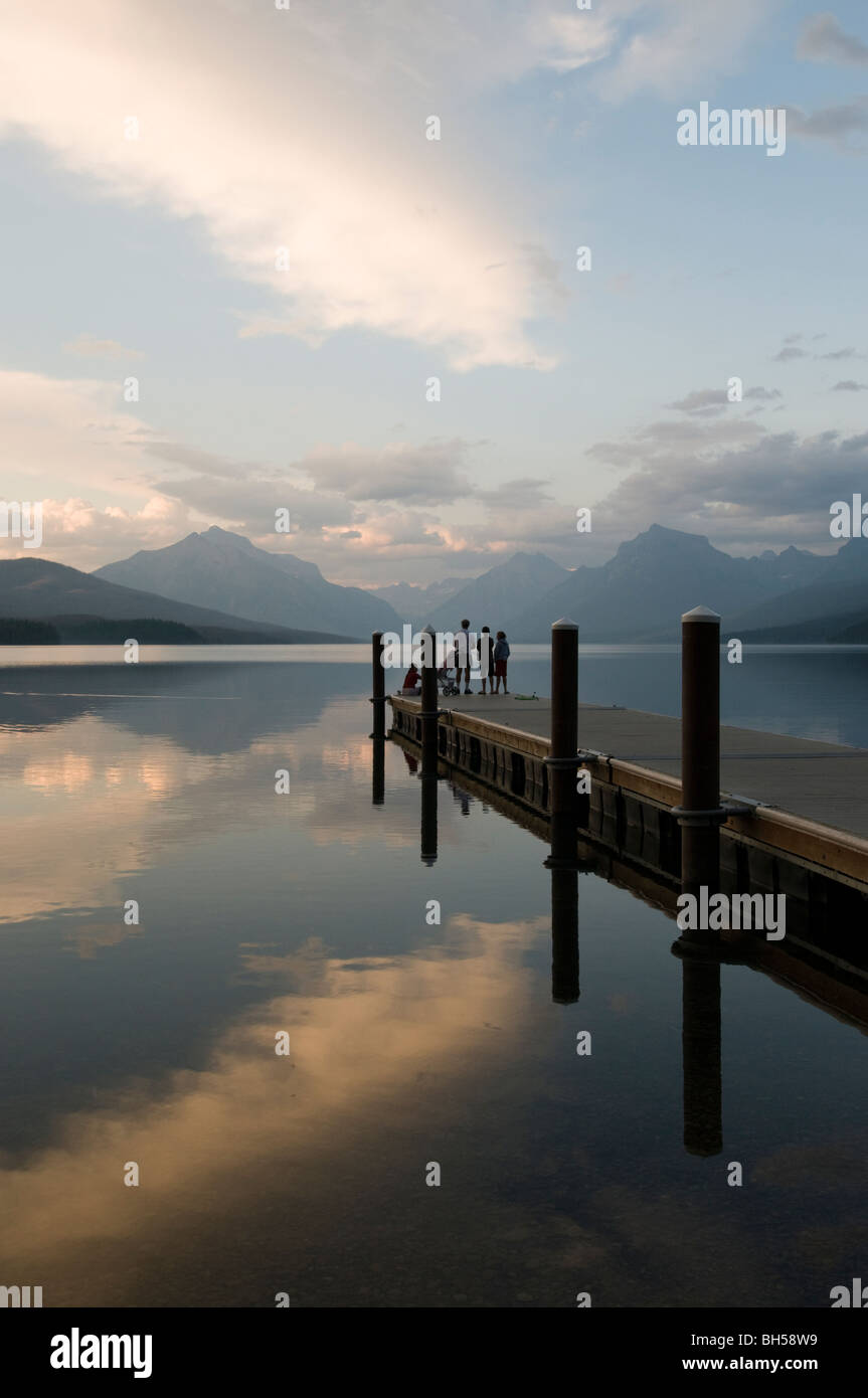 Les gens sur le lac McDonald dock au coucher du soleil Banque D'Images
