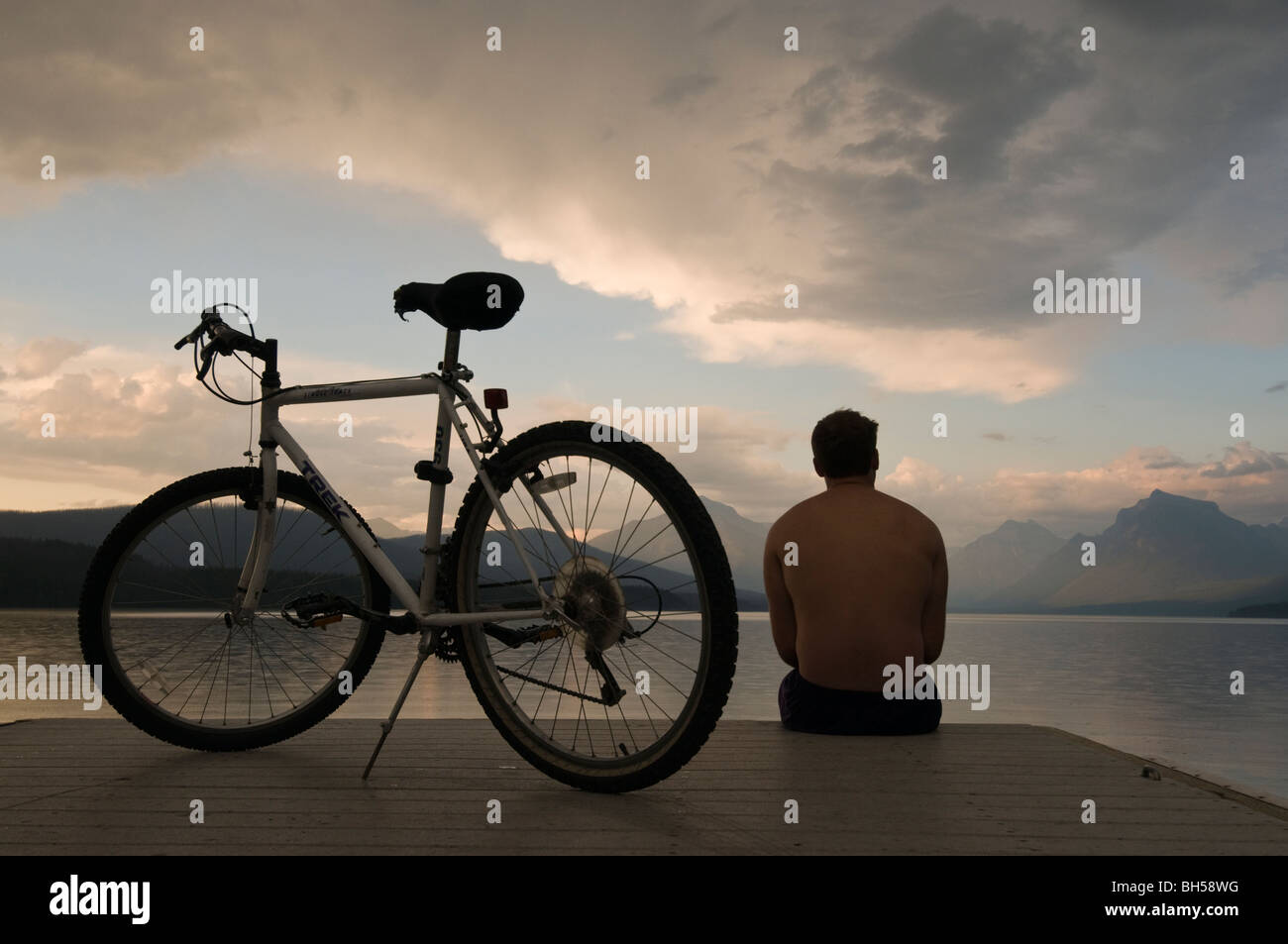 Cycliste sur dock McDonald Lake at sunset Banque D'Images