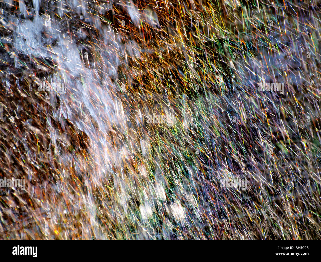 La lumière du soleil par les gouttelettes d'eau d'une chute causant un effet arc-en-ciel. Banque D'Images