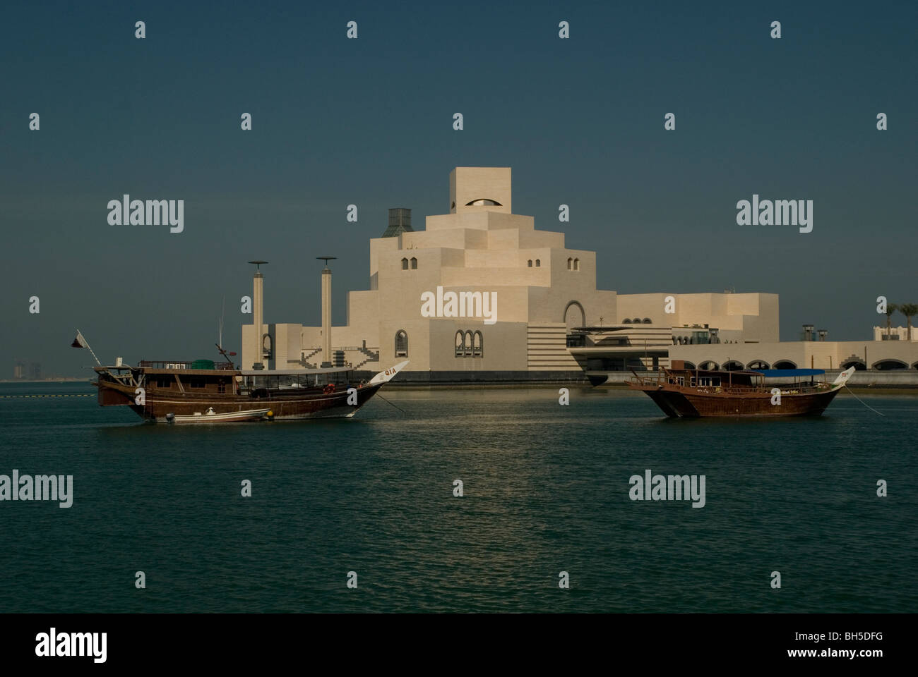 Vue extérieure du Musée d'Art islamique de Doha, Qatar, avec des bateaux de pêche en dhow au premier plan Banque D'Images