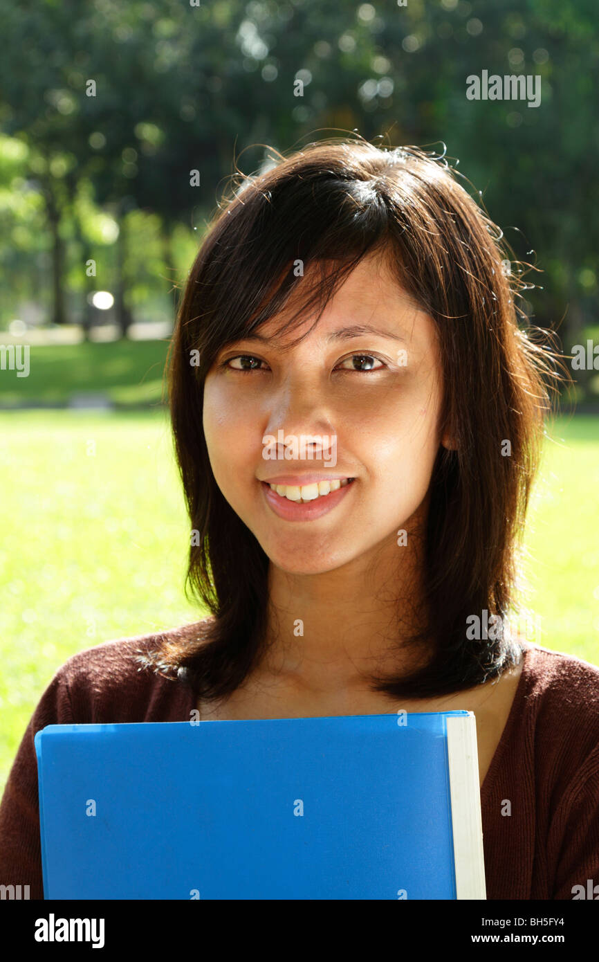 Une asiatique college student smiling dans un parc public Banque D'Images