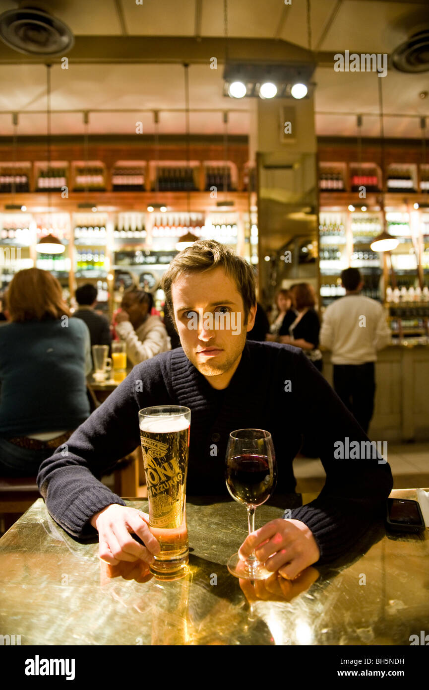 Un jeune homme de boire dans un bar Banque D'Images