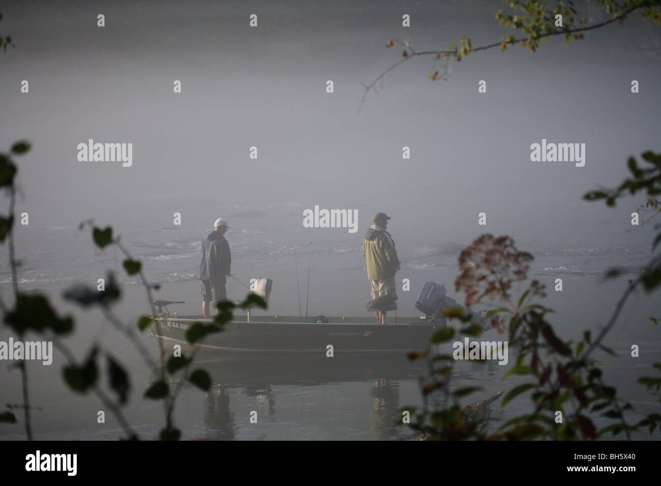 Deux pêcheurs de voile Pêche en rivière un épais brouillard MAUVAIS TEMPS tôt le matin, le modèle ne libération Banque D'Images