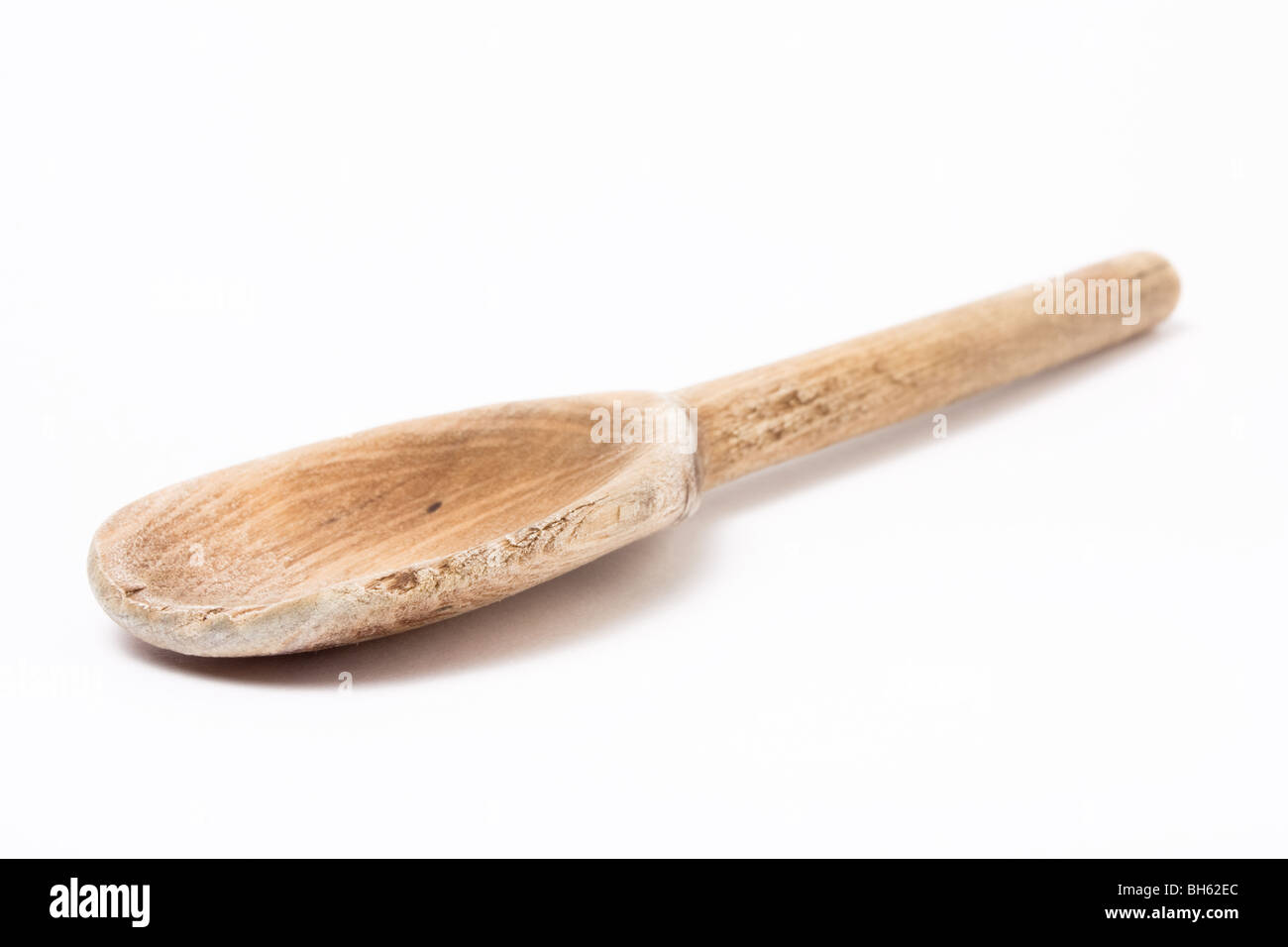 Cuillère en bois bien isolé contre cuisine fond blanc. Banque D'Images