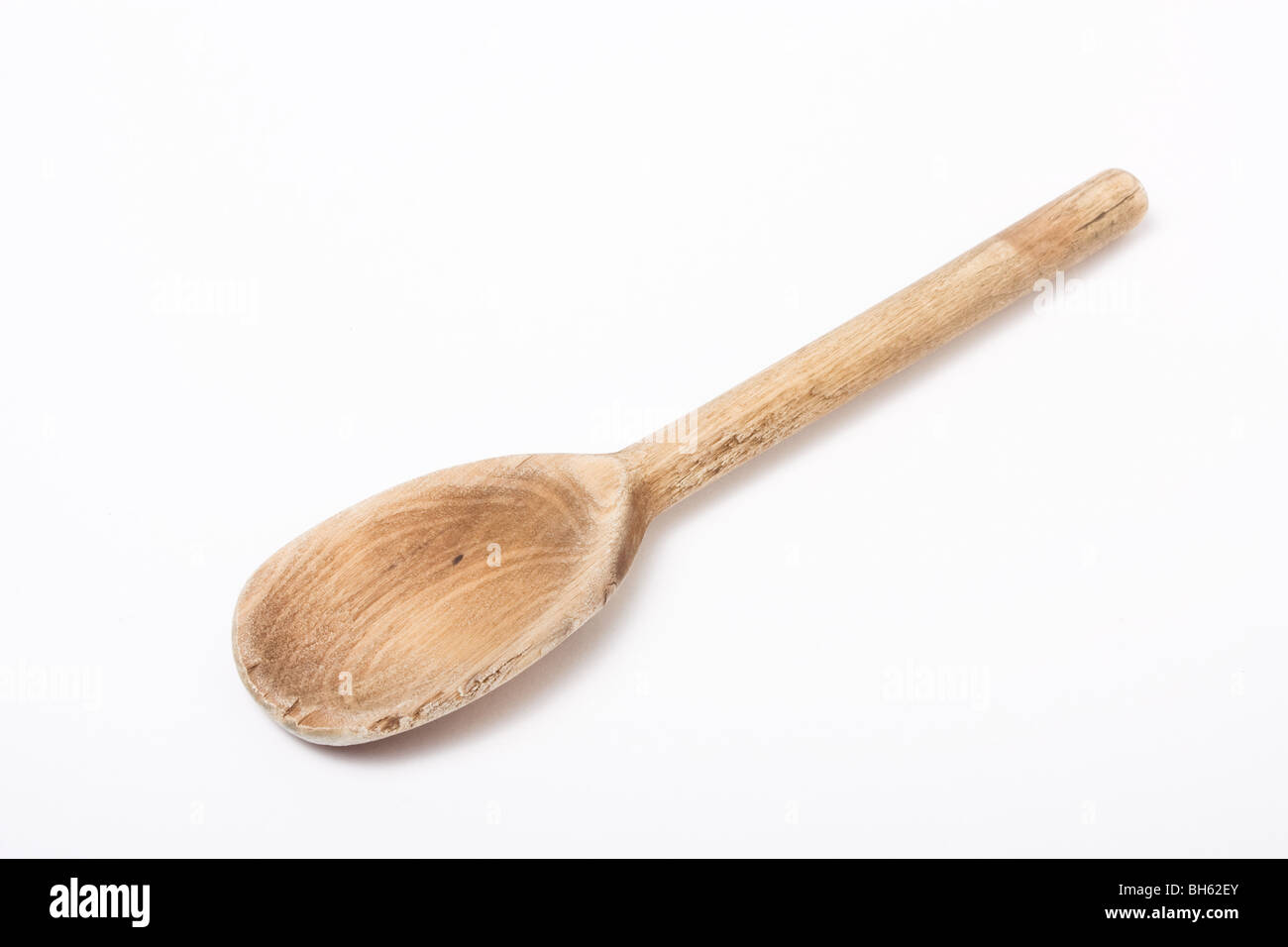 Cuillère en bois bien isolé contre cuisine fond blanc. Banque D'Images