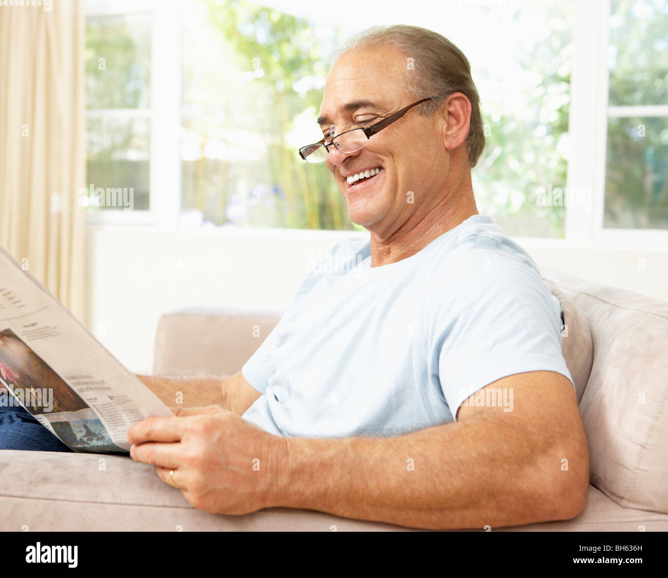 Senior Man reading Newspaper At Home Banque D'Images