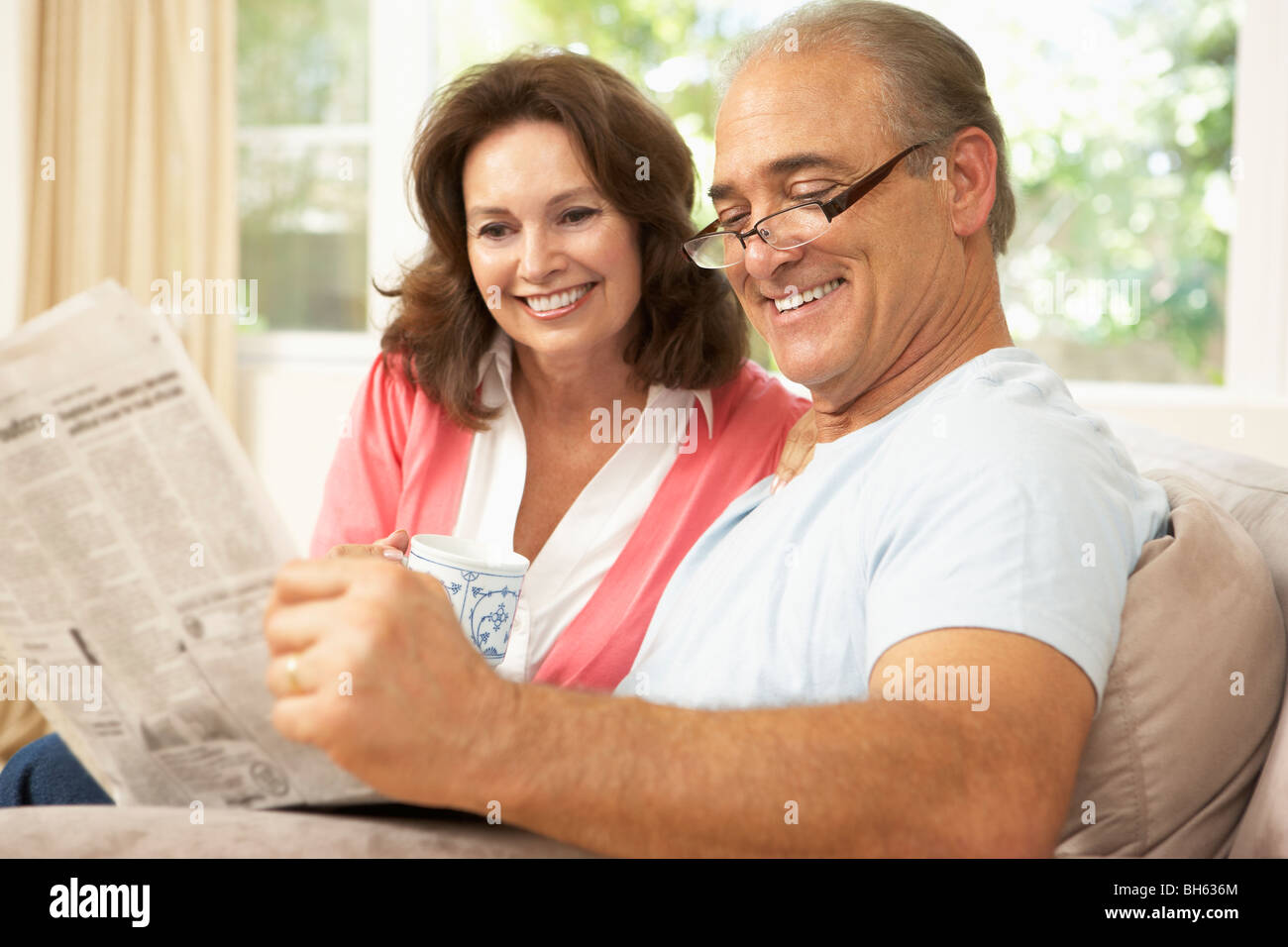 Senior Couple Reading Newspaper At Home Banque D'Images