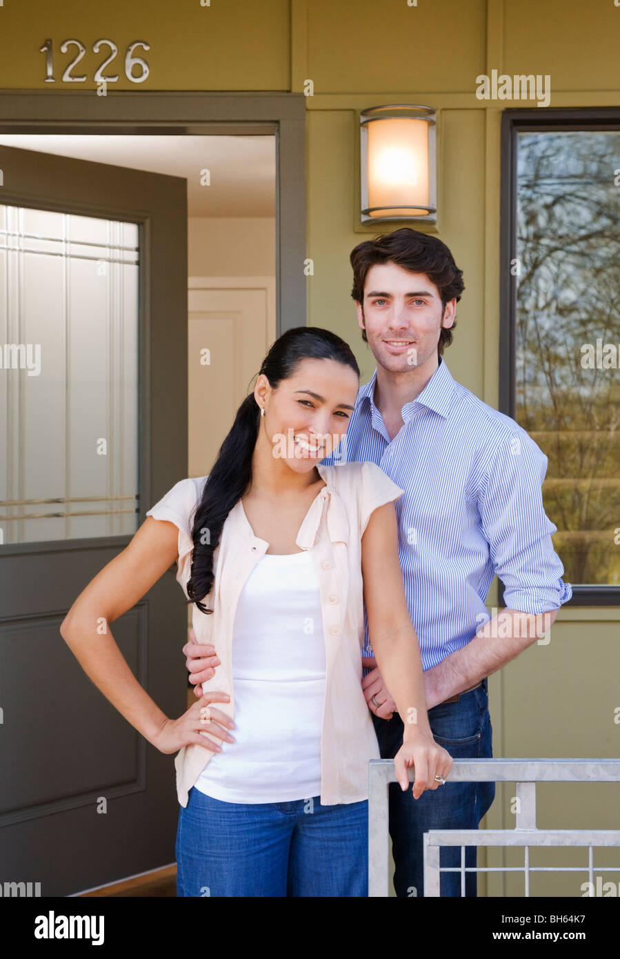 Couple sur porche avec sold sign Banque D'Images