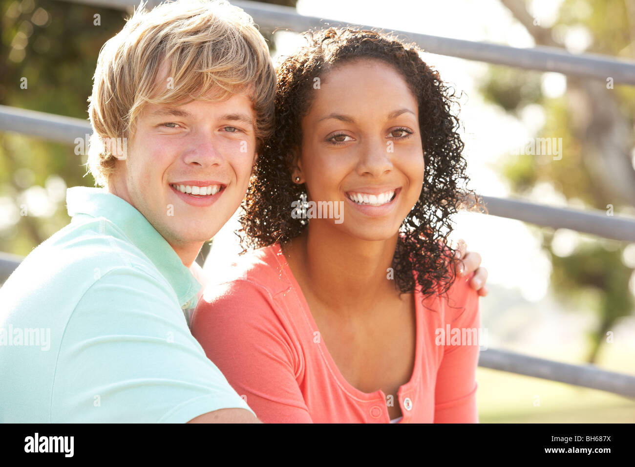 Teenage Couple Sitting in Playground Banque D'Images