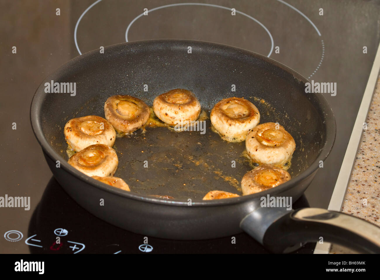 Champignons frais d'être sautés dans une poêle Banque D'Images