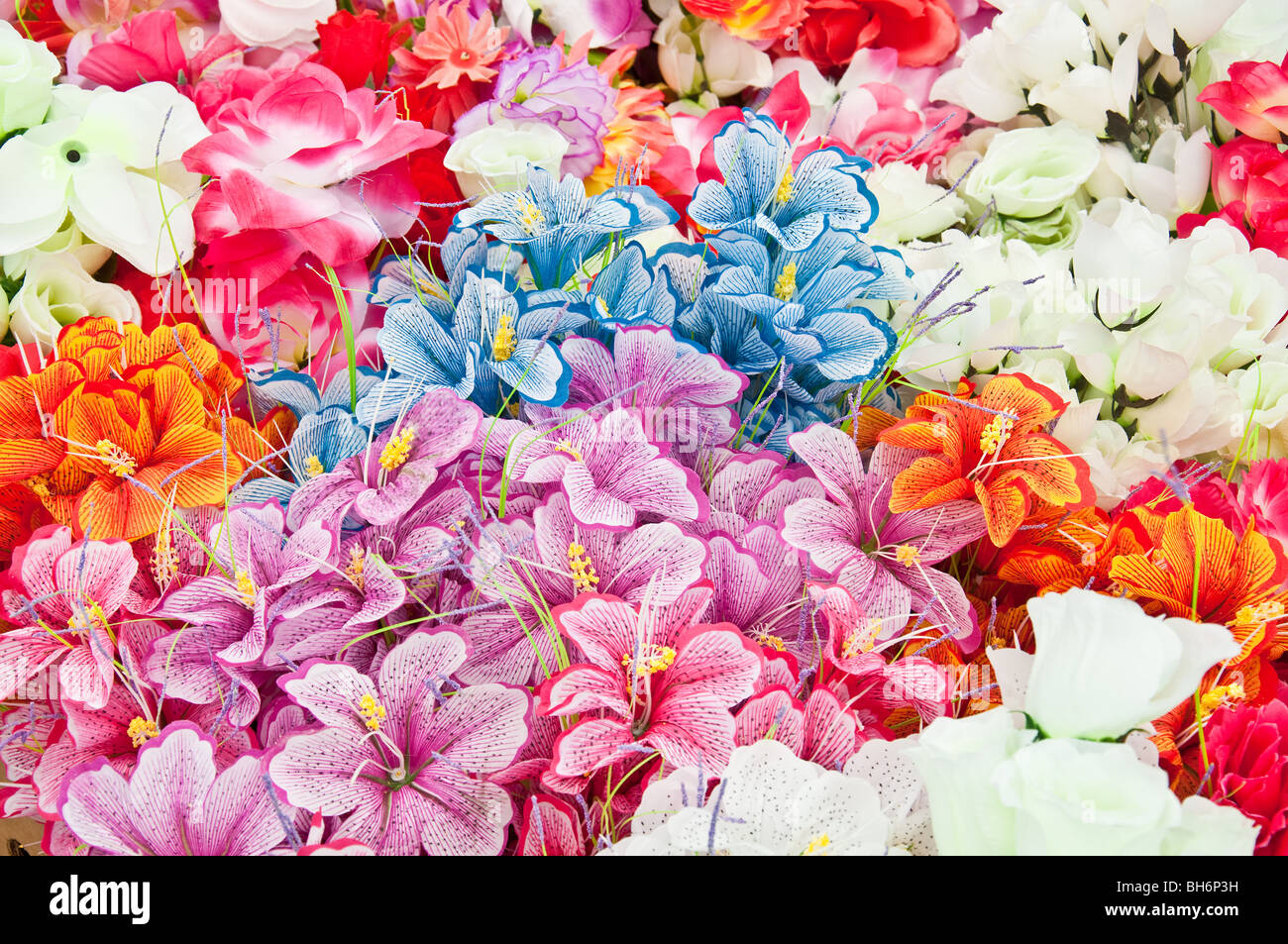 Différentes fleurs artificielles aux couleurs vives pour la vente au marché aux puces Banque D'Images