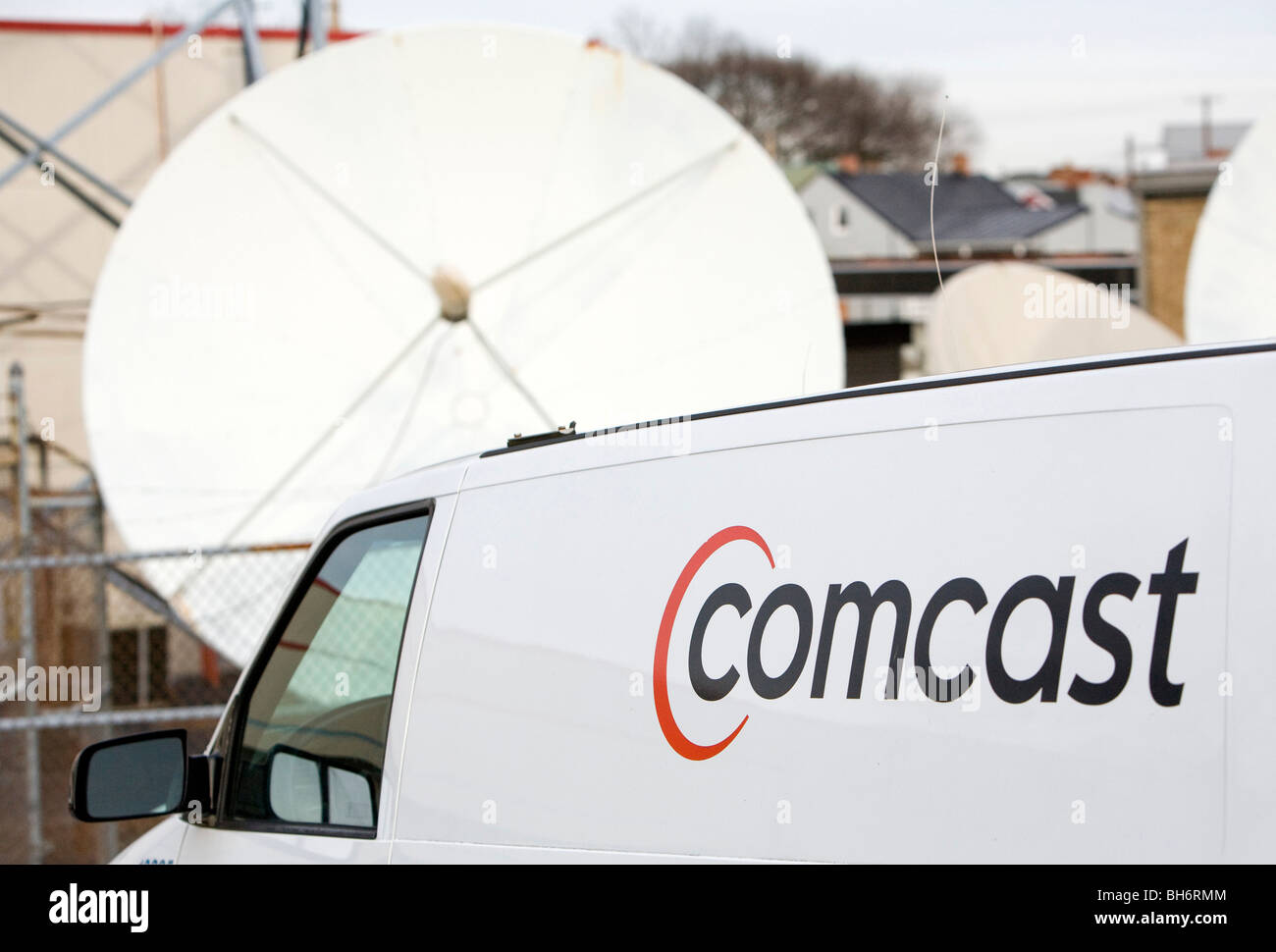Comcast Corporation un logo sur un véhicule en face d'une antenne parabolique. Banque D'Images