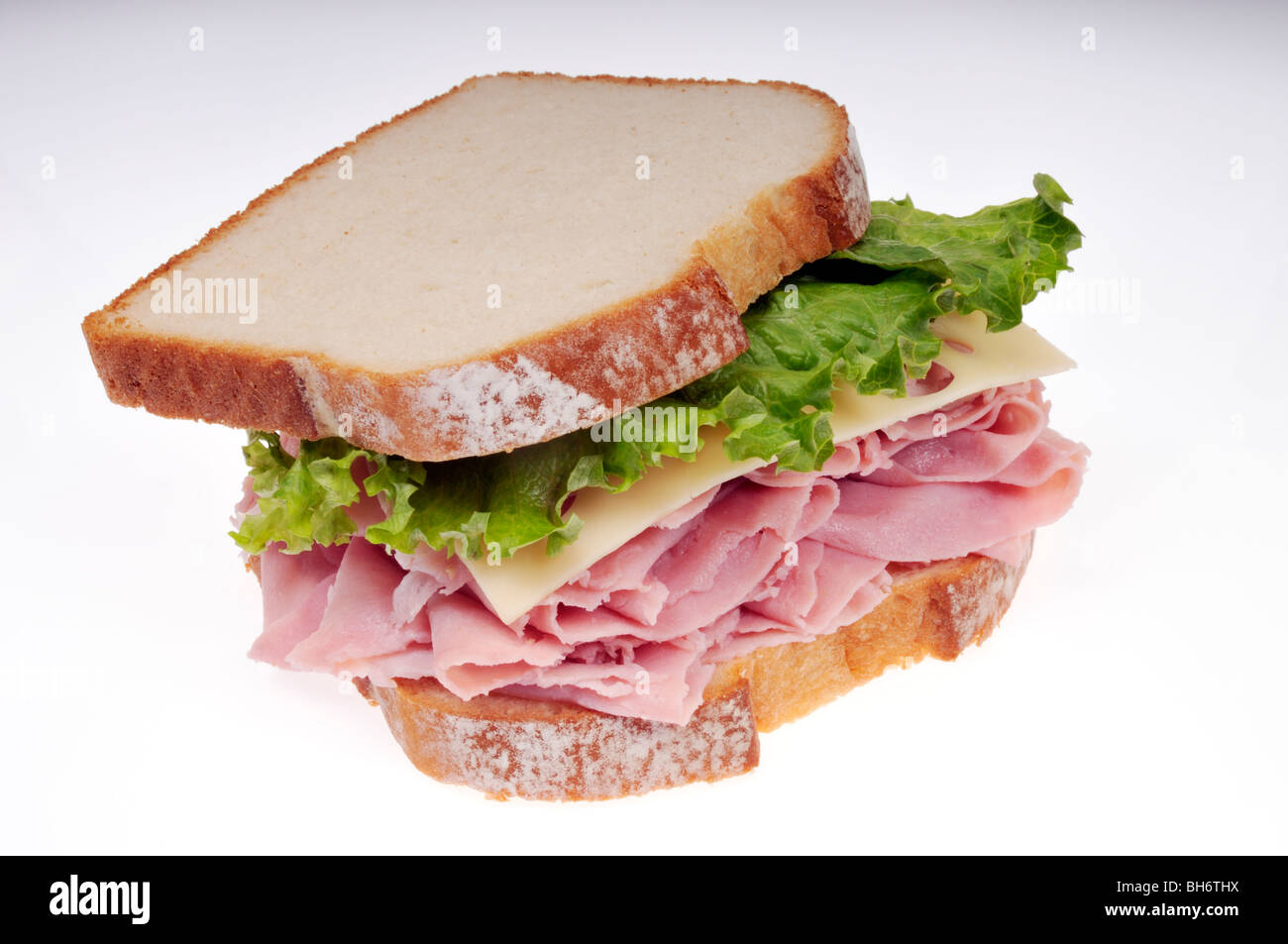 Sandwich au jambon et fromage avec salade sur le pain blanc sur un fond blanc. Banque D'Images