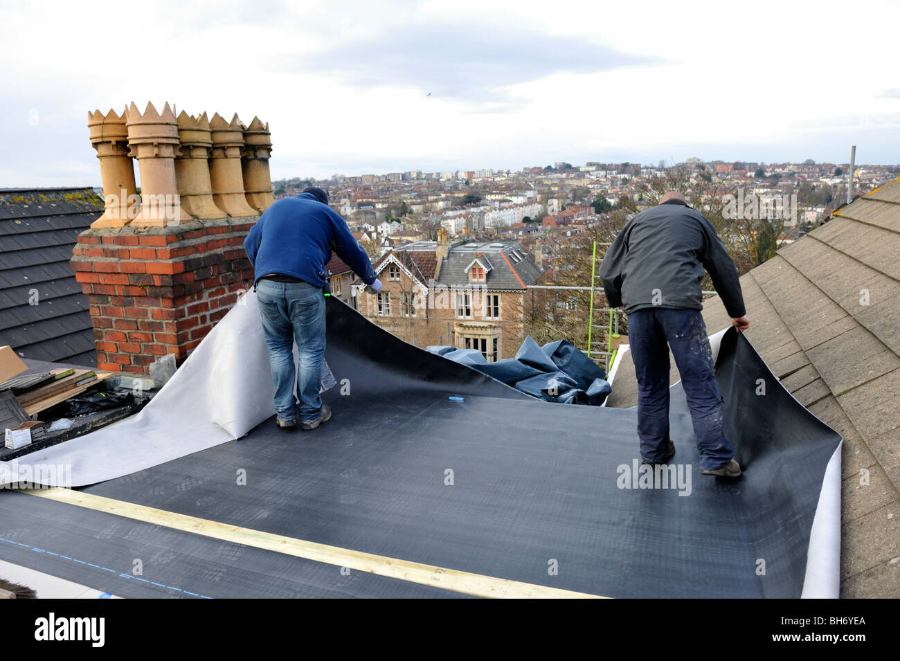 Les couvreurs la réparation de toit plat avec nouvelle membrane en caoutchouc EPDM sur house Banque D'Images