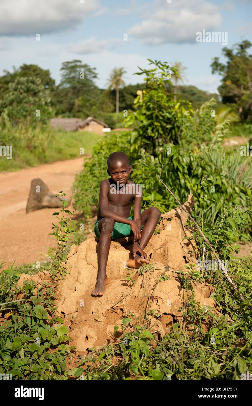 Jeune garçon africain sur termitière dans Tinkoko(r) de la Sierra Leone. Banque D'Images