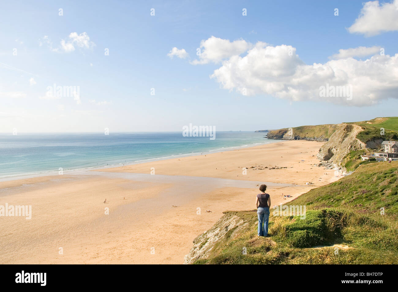 Femme sur la falaise à la recherche sur la plage, côte, Baie de Watergate, Cornwall, sud de l'Angleterre, Royaume-Uni, Europe Banque D'Images