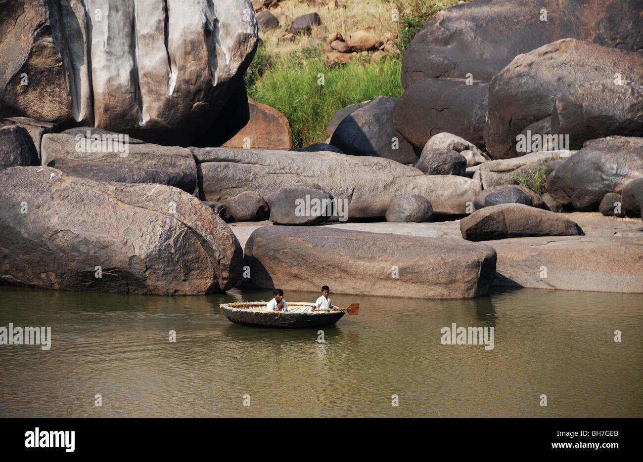 Deux garçons à l'intérieur d'un bassin pour enfants Coracle sur la rivière Tungabhadra dans Hampi, Inde. Banque D'Images
