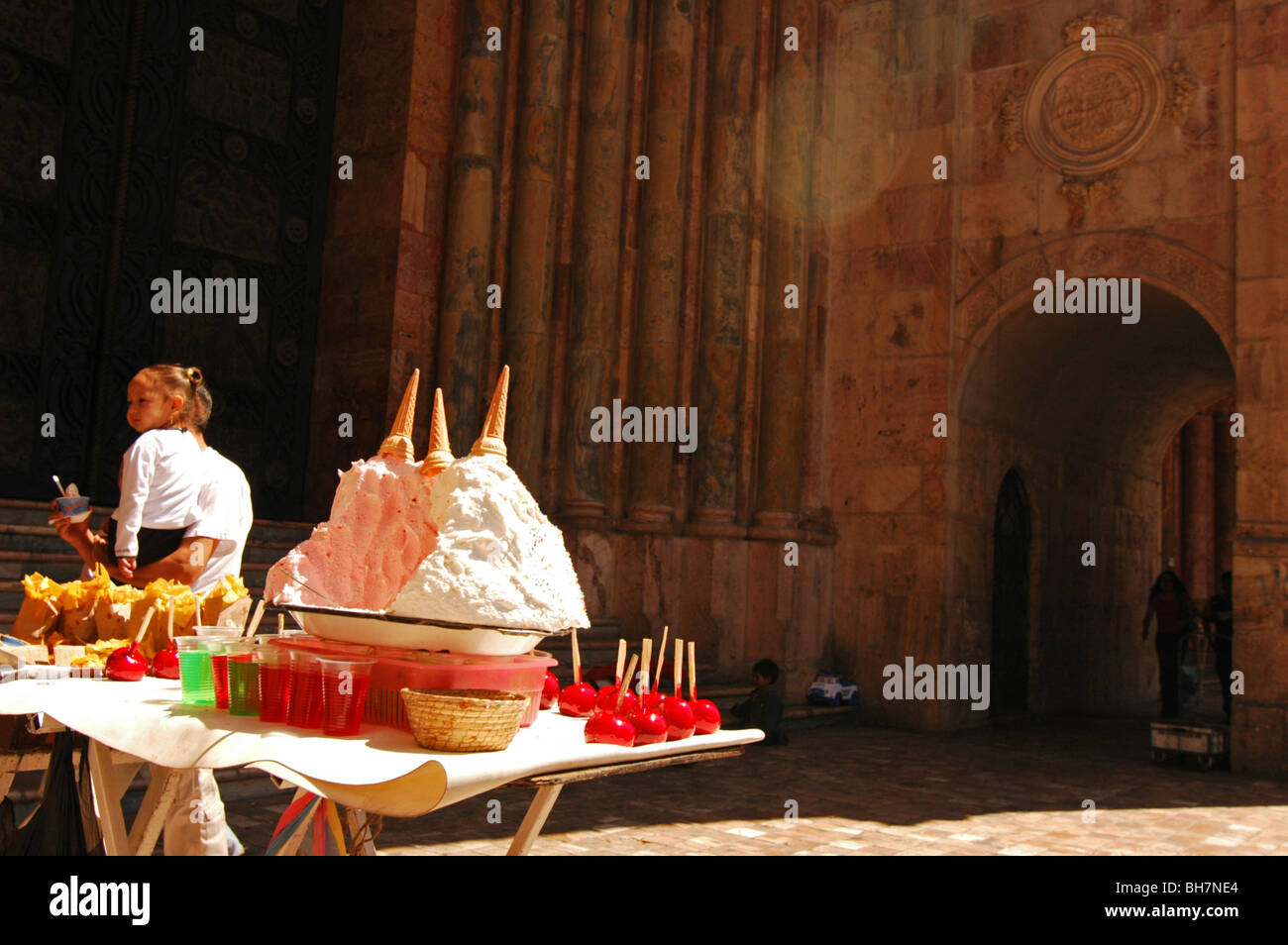 L'Equateur, Cuenca, vue sur des montagnes de glace et les pommes d'amour rouge affiché dans le soleil, sur une table en bois, une petite fille adoptée Banque D'Images