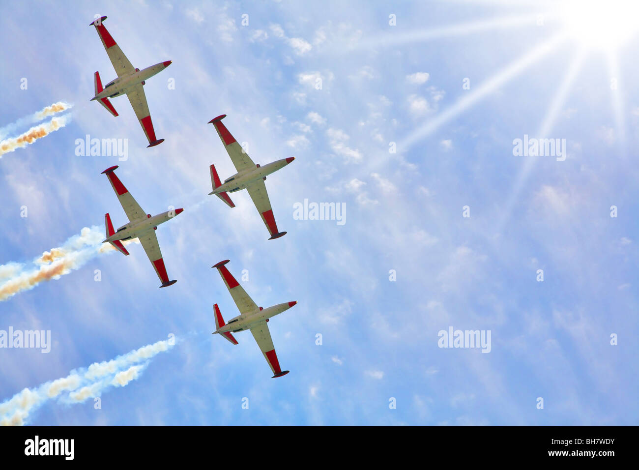 Vol synchrone dans les faisceaux du soleil de quatre avions mousseux sur la parade festive Banque D'Images Vol synchrone dans les faisceaux du soleil de quatre avions mousseux sur la parade festive Banque D'Images
