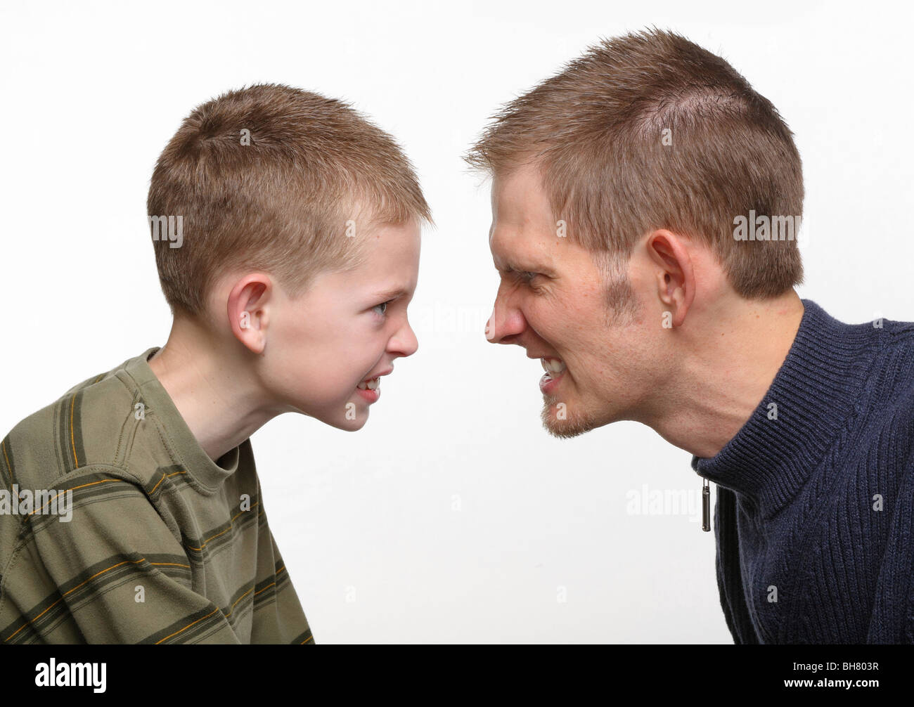 Gros plan du père et fils préadolescentes avec faces en colère près l'un de l'autre Banque D'Images