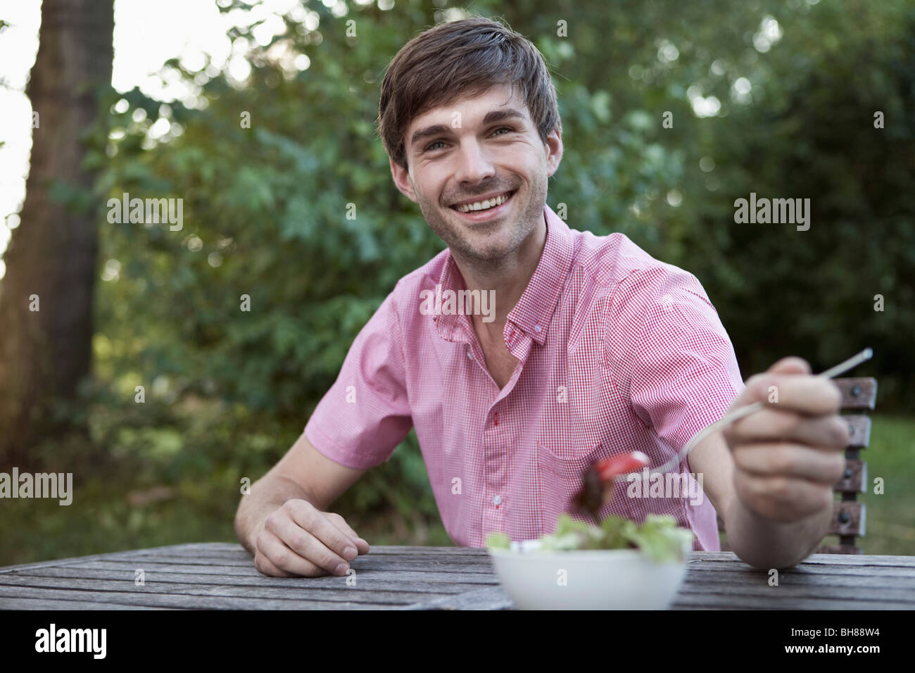 Un homme de manger à une table en plein air, scène non urbaines Banque D'Images