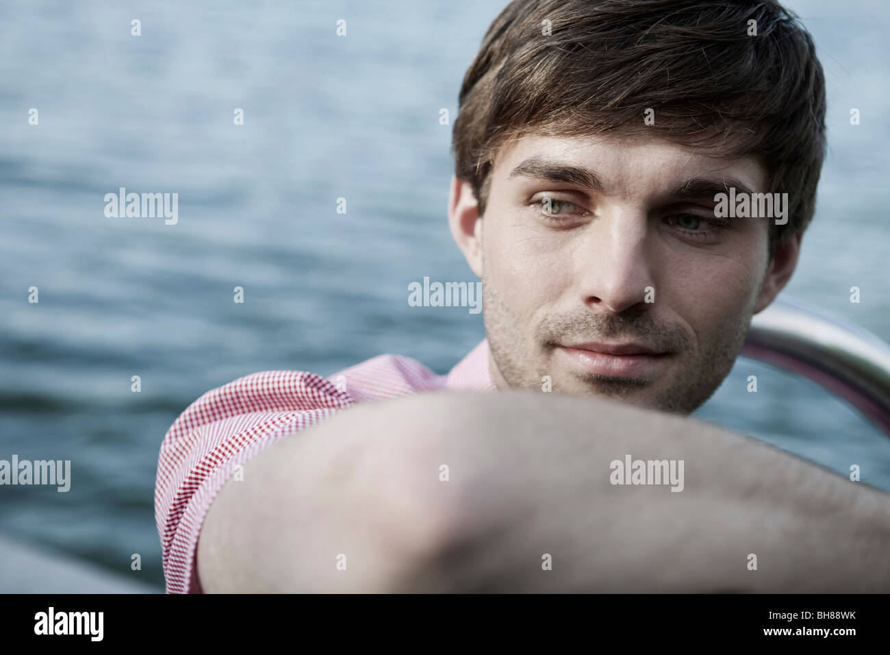 Un homme se détendre au bord d'un lac, la tête et épaules Banque D'Images