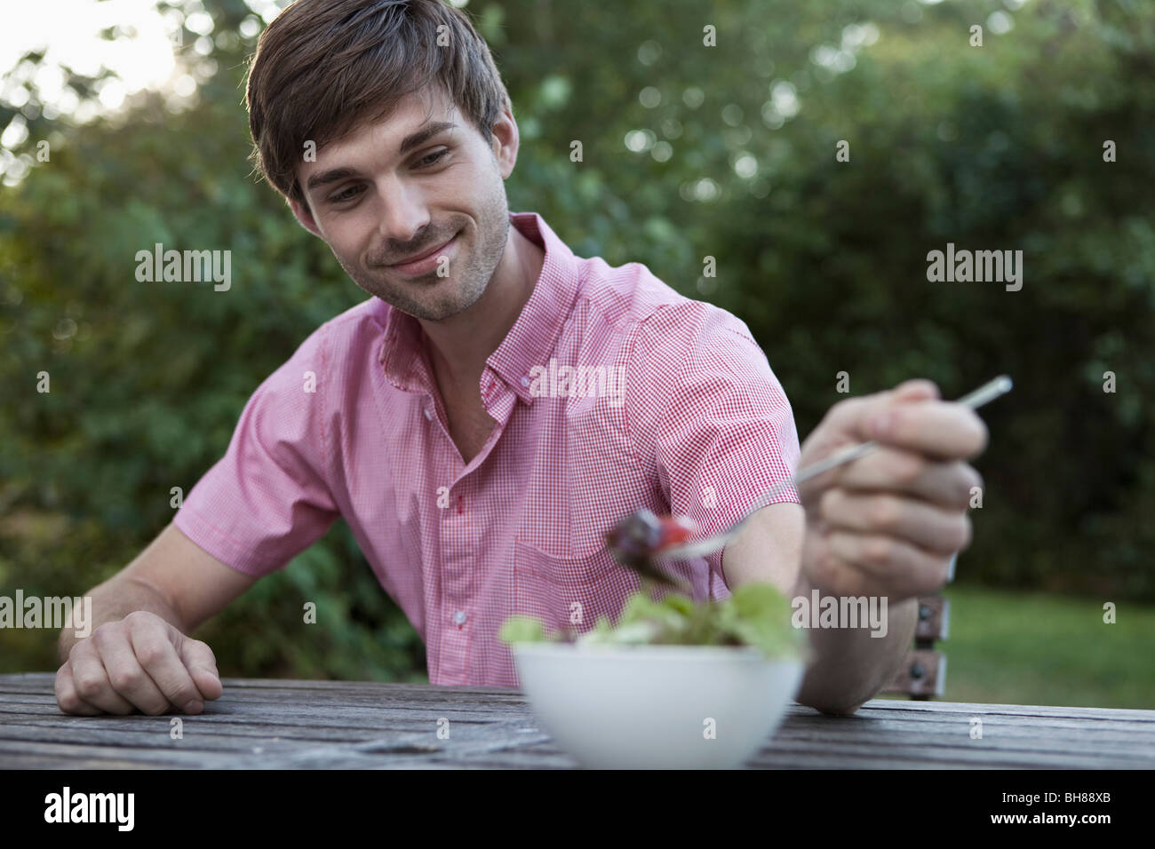 Un homme de manger à une table en plein air, scène non urbaines Banque D'Images